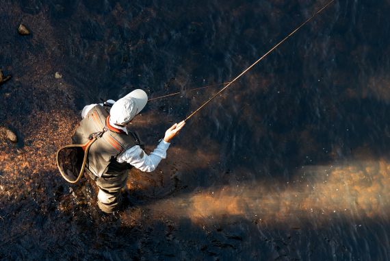 An individual standing in a rivier while fishing