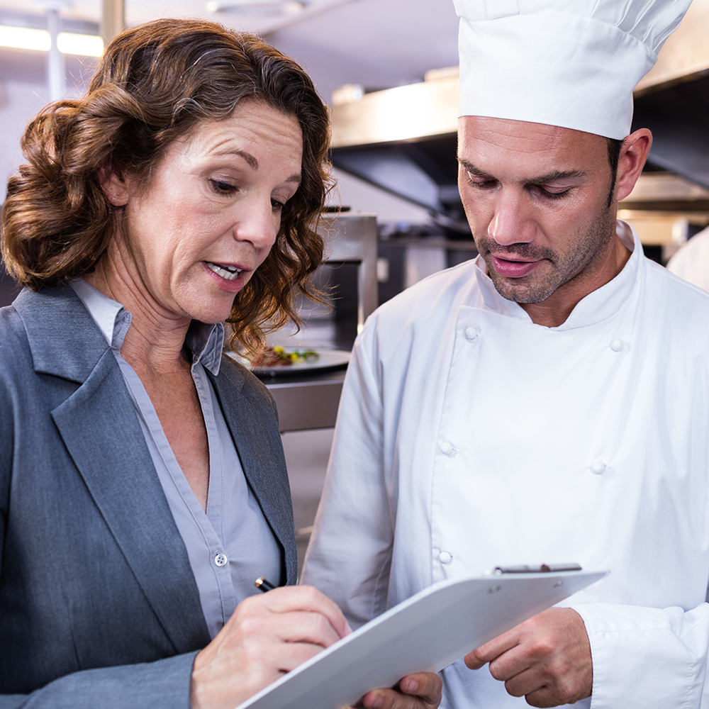 Man and woman reviewing a clipboard