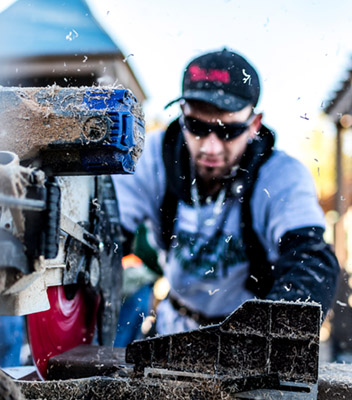 person cutting wood with a saw