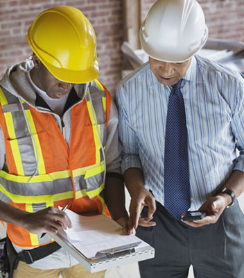 Two construction workers looking at documents