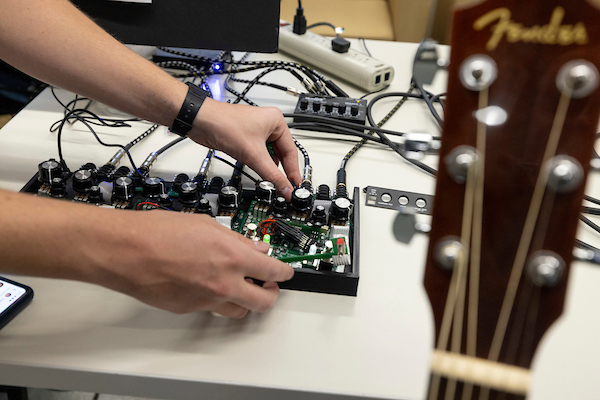 hands working on an electrical wiring board