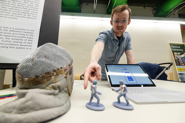 student gesturing to minifigures on a table
