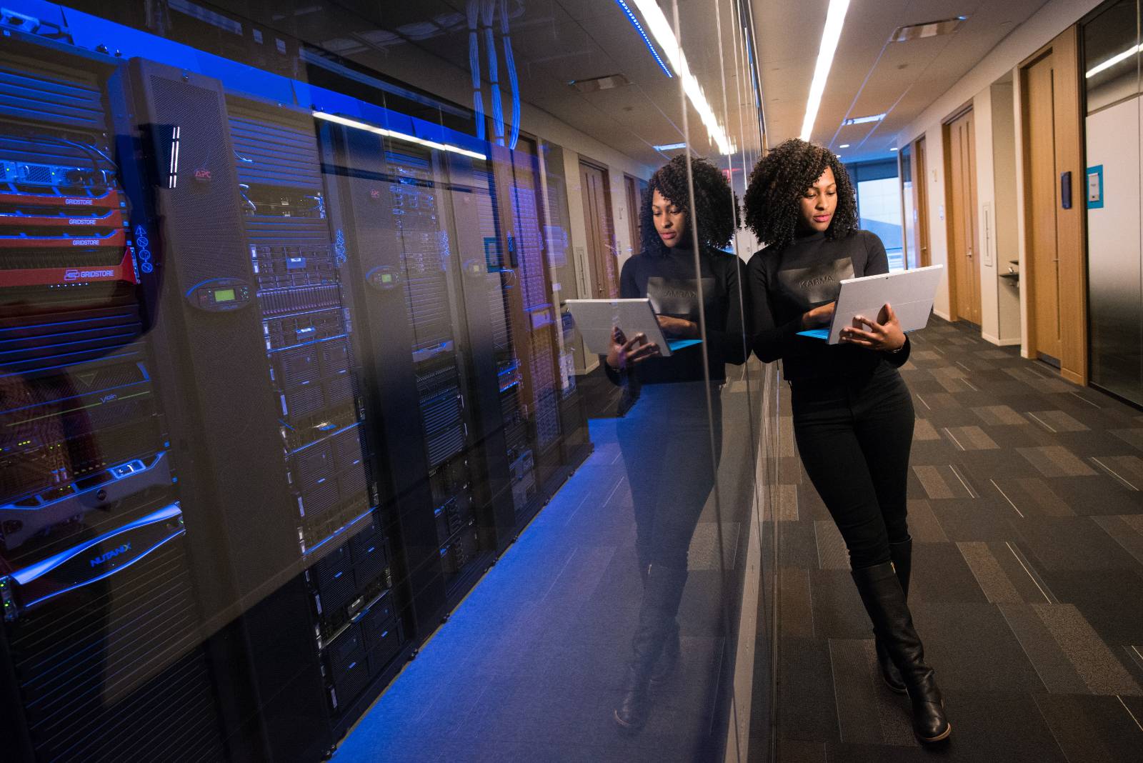 woman standing in hallway with a laptop