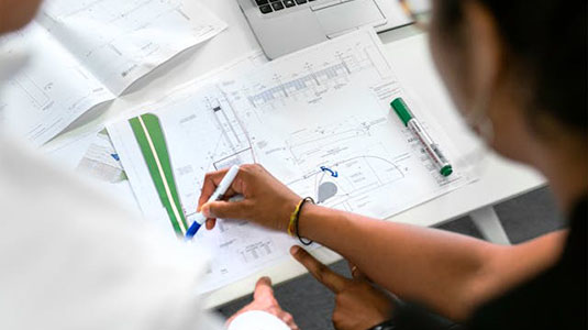 woman drawing blueprints