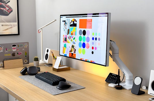 computer on a desk with colorful images on screen