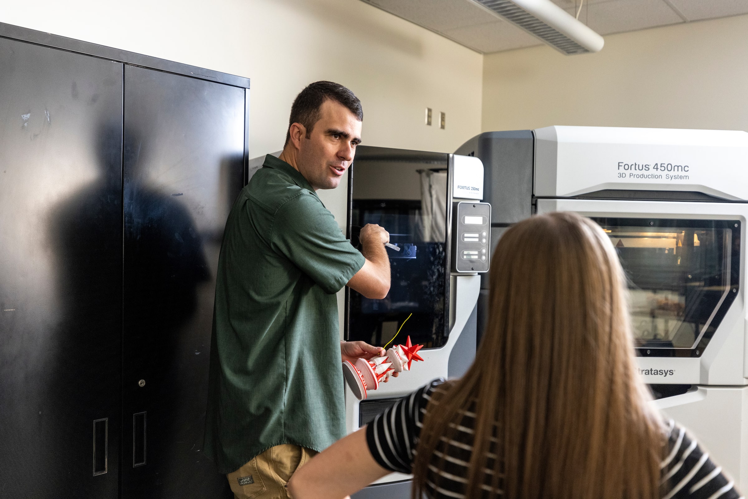 Teacher showing how a 3D printer works