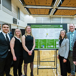 group of people standing in front of a poster