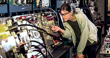 woman using a panel of electronics equipment