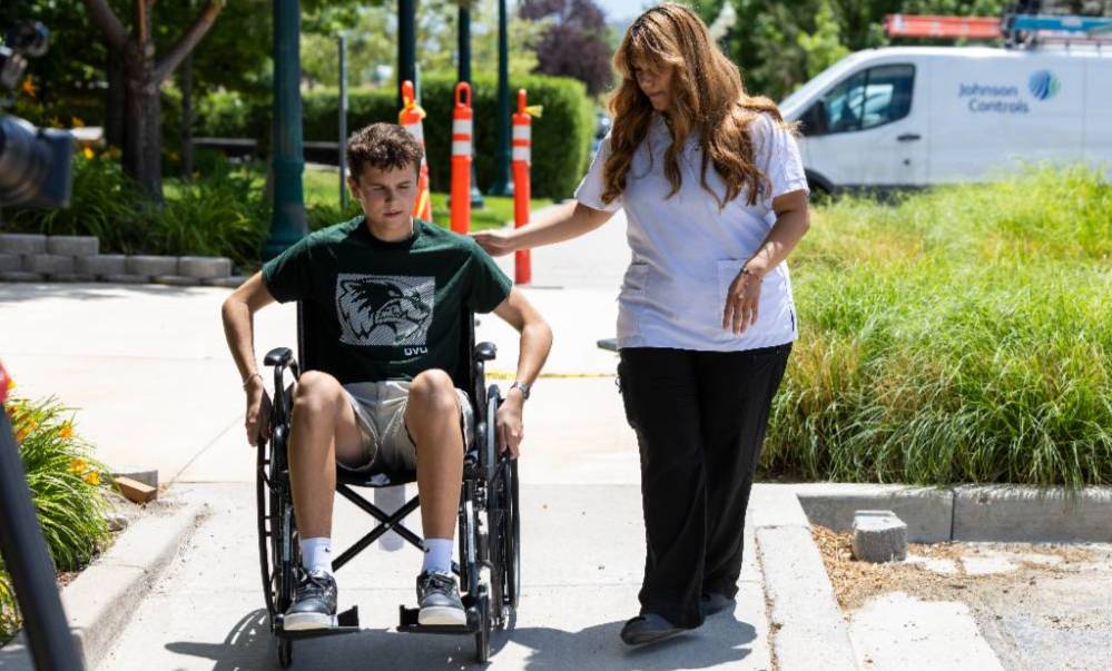 woman walking a man in wheelchair