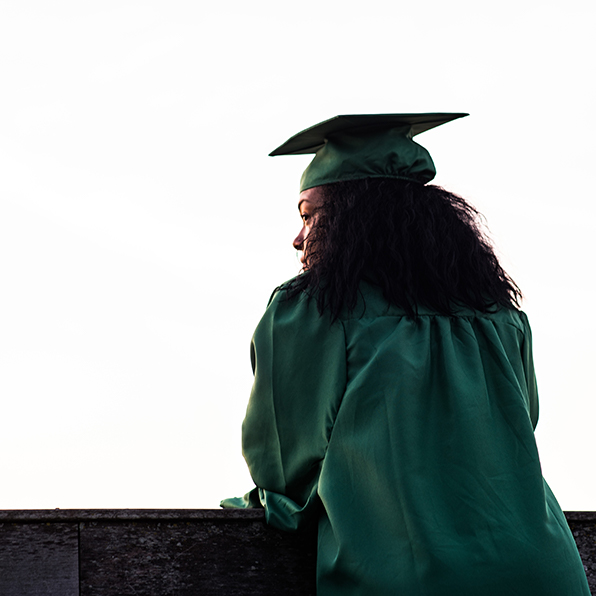 student in graduation attire looking left