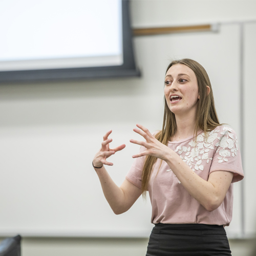 female student speaking in front of class