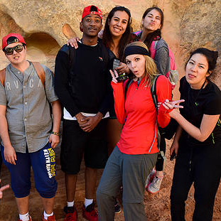 Students Standing in front of a big rock in a canyon