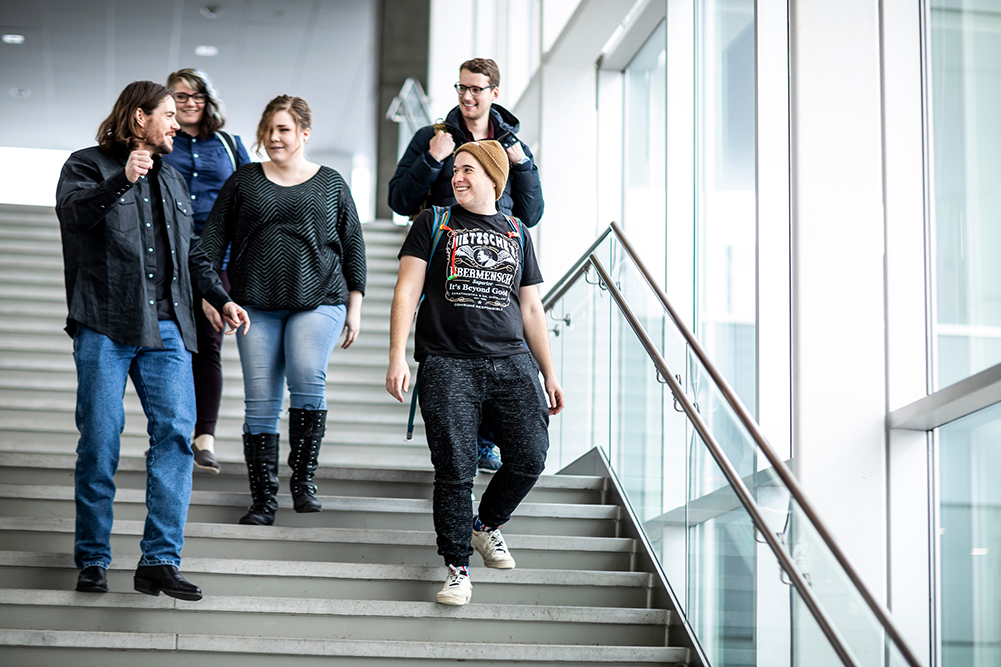 Group of students conversing while descending the stairs