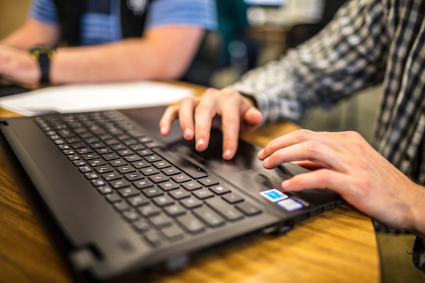 Person using a laptop on a table.