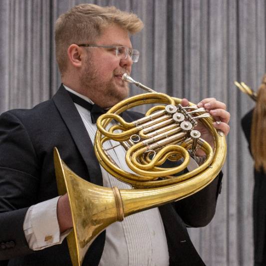 man playing a french horn