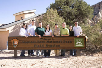 Friends standing in behind a sign for the Capitol Reef Field Station