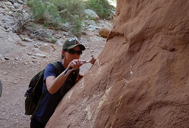 Removing graffiti from standstone rock in the park