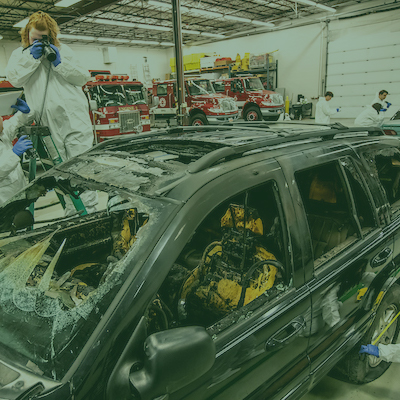 students photographing burnedout car