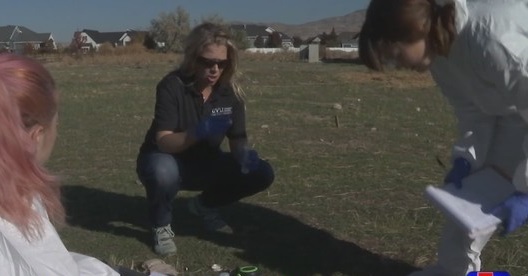 Amie Houghton showing two students something at the pigdig site