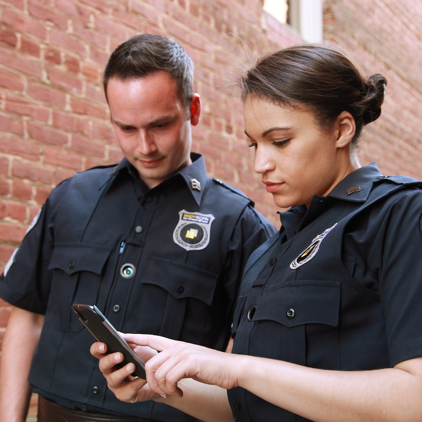 Policeman and woman looking at a phone