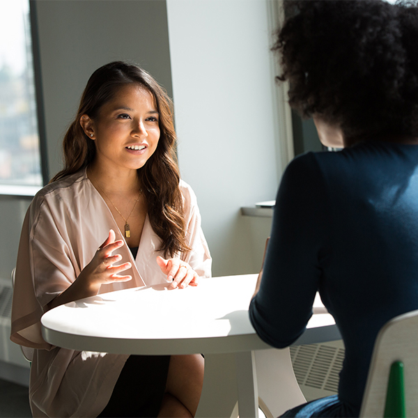 two women talking at a table