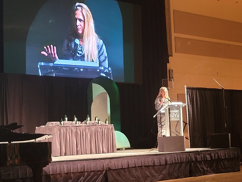 Amie standing at podium accepting award