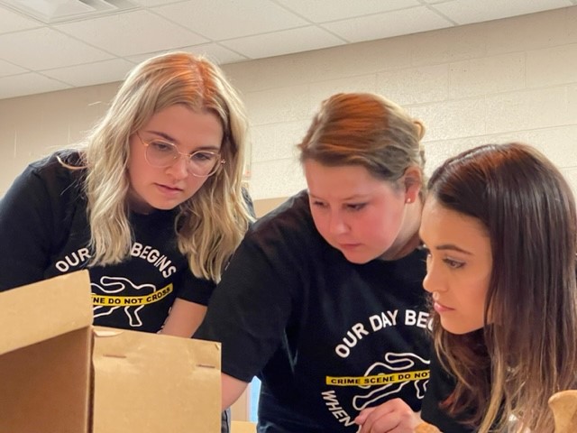 three students reviewing evidence.