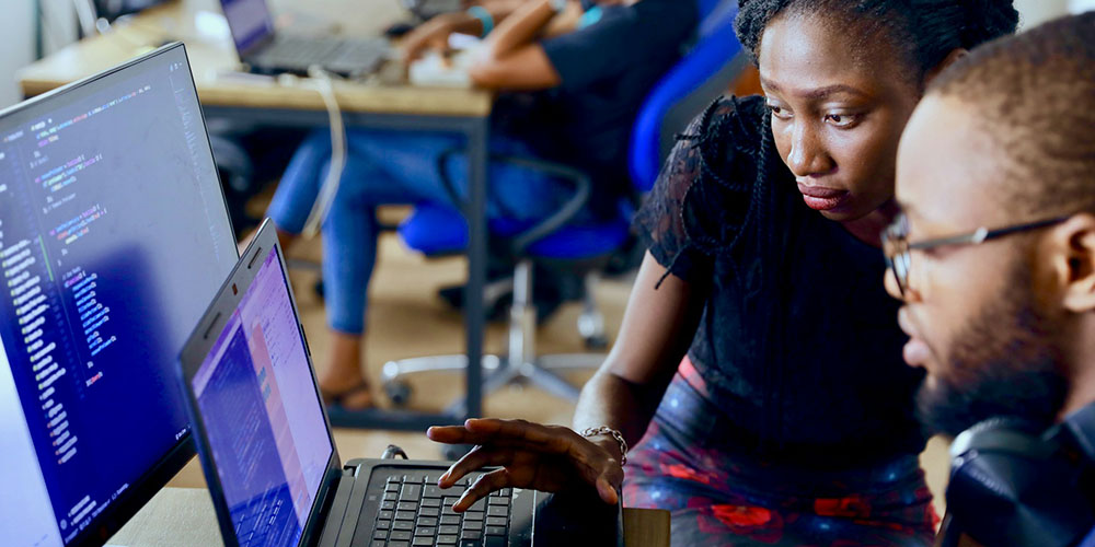 woman helping a man on a computer