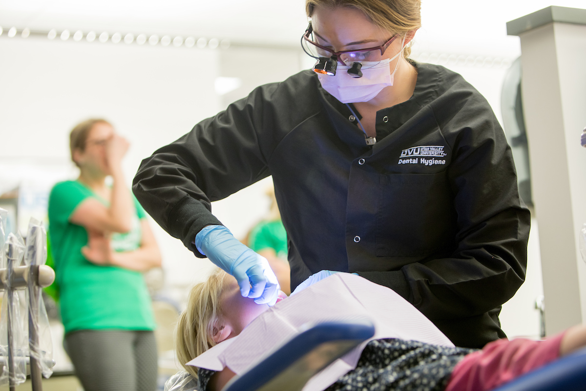 Image of a dental assistant cleaning a patients teeth