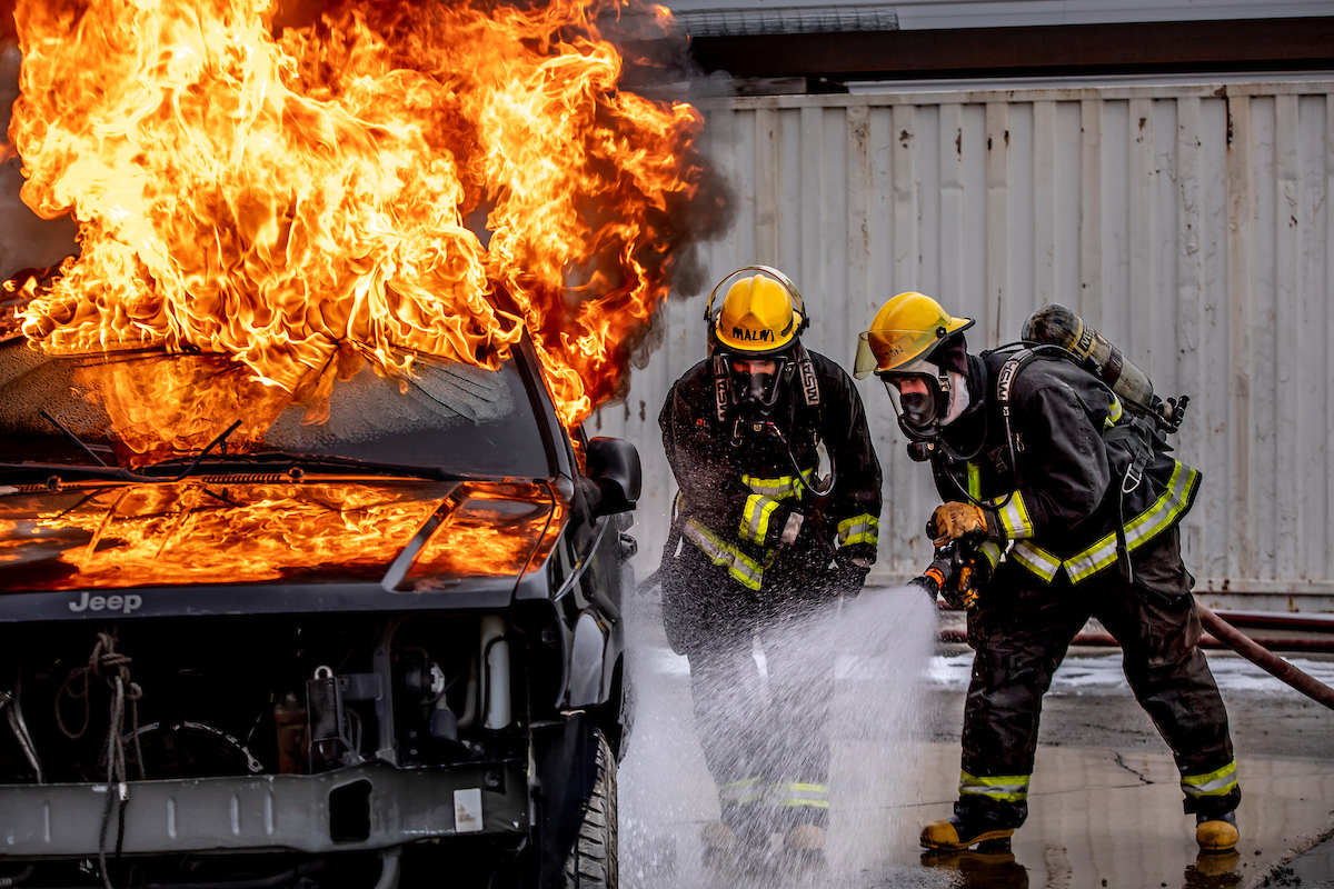 Image of the fire department putting out a car on fire