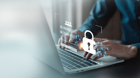 close up of person working on laptop with lock icon hovering over mousepad