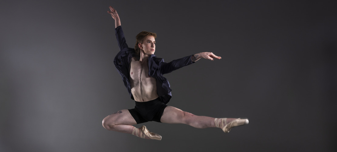 Ballet student doing a stag jump in pointe shoes