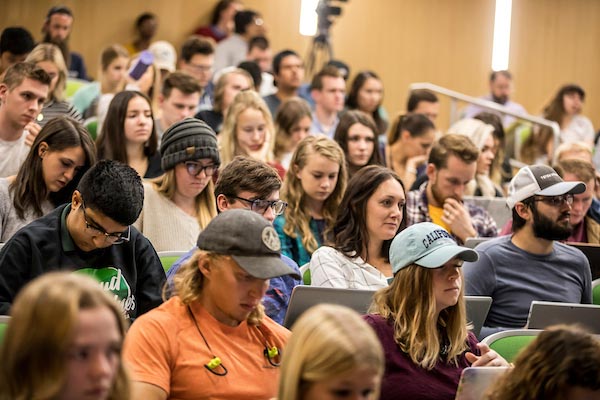 Students sitting in an auditorium listening to a lecture.