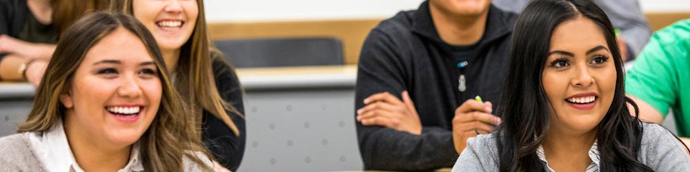 Students sitting in a classroom, listening to a lecture.