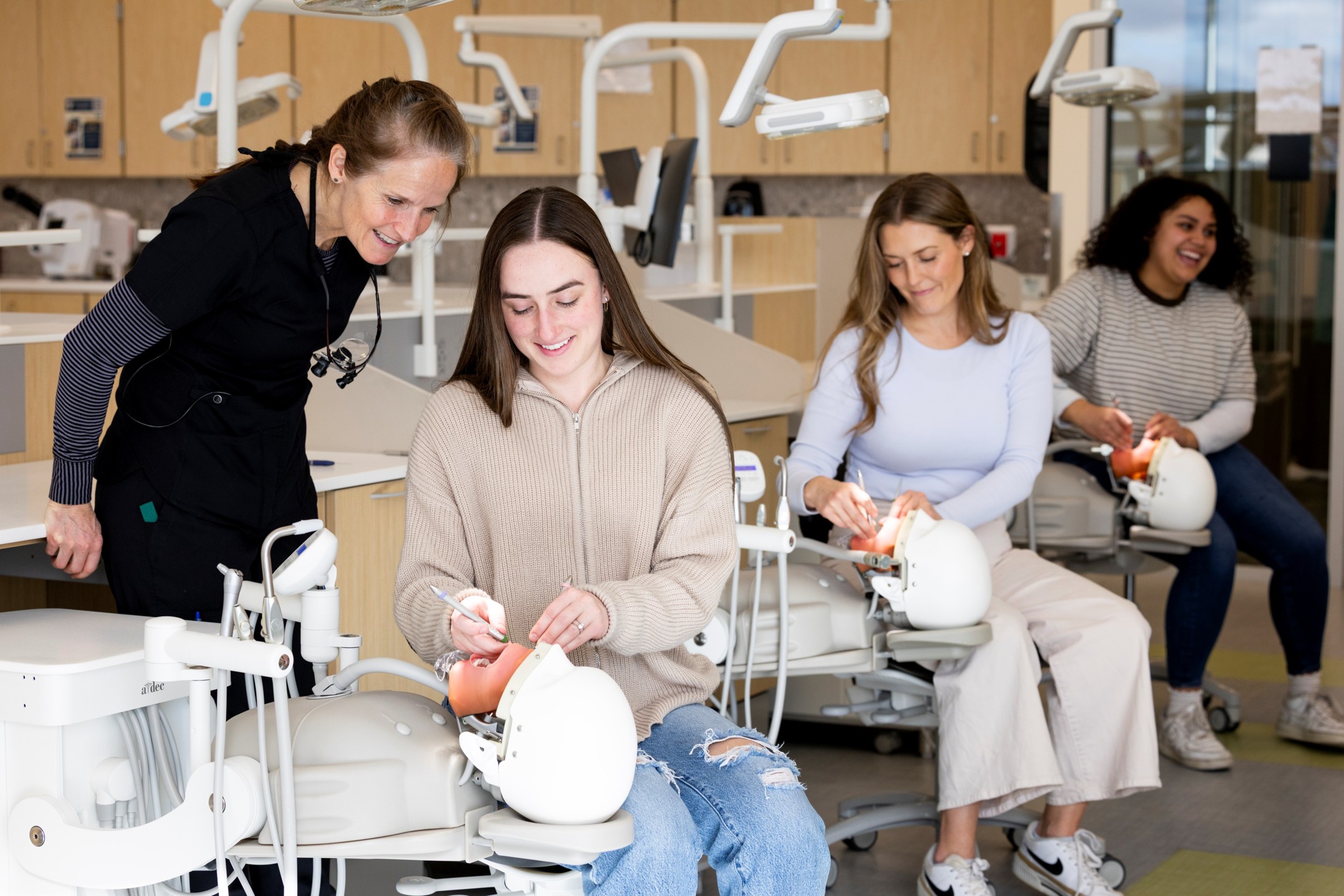 Dental Hygiene students in lab with instructor working on a manakin