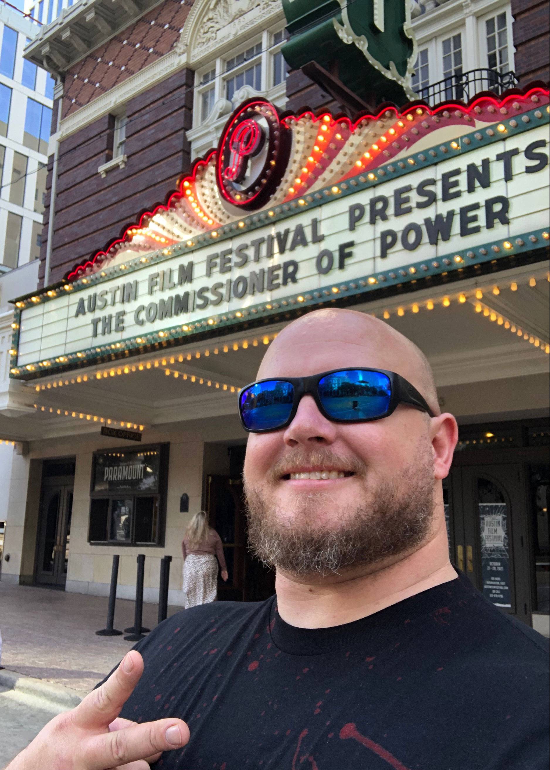 Bryan Sansom standing in front of the marquee for The Commissioner of Power
