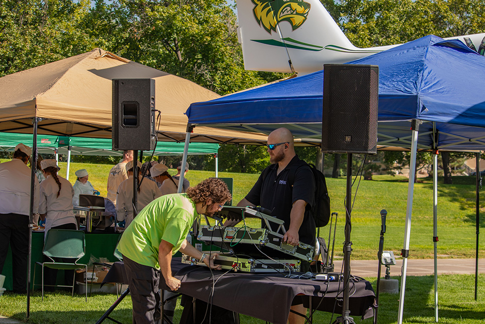Professor Bryan Sansom setting up the audio equipment with a student