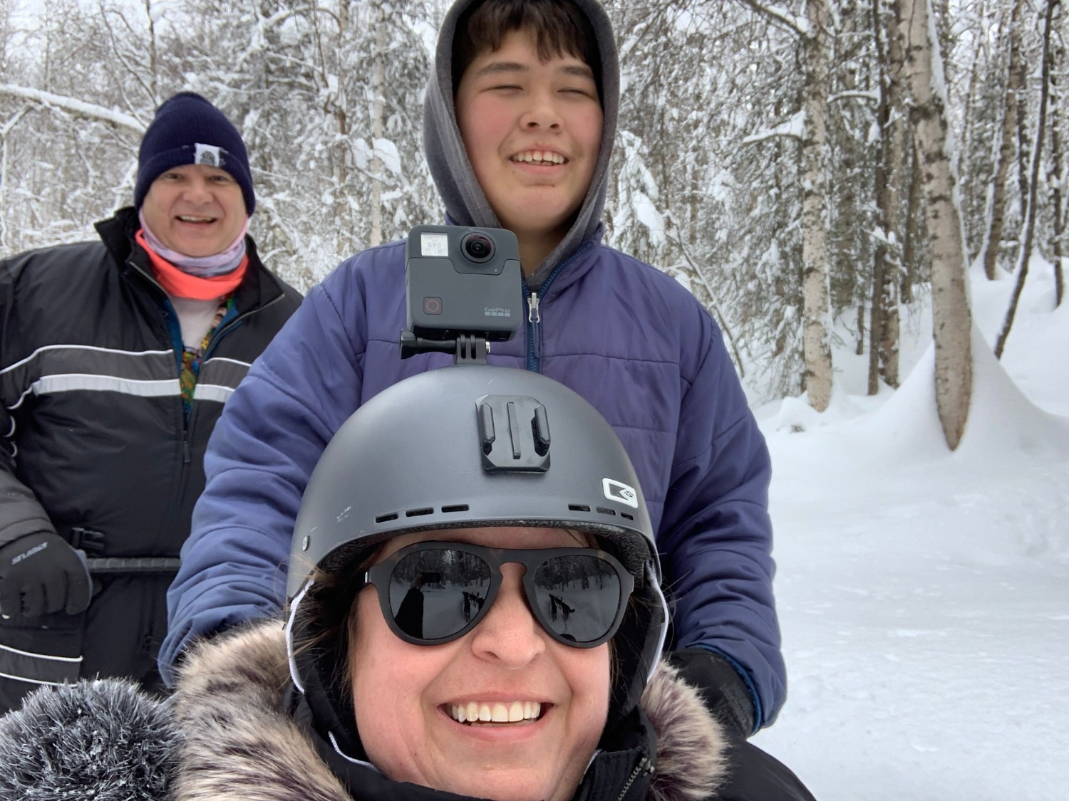 Emily Wisland is wearing a GoPro while capturing images on a dogsled with musher Samuel from Snowhook Kennels behind her and Mike Wisland taking up the rear.