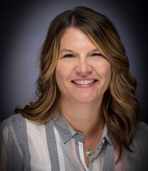 Photograph of Kim Shaw female with long brown hair highlighted around her face