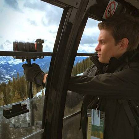 man filming out window of a gondola