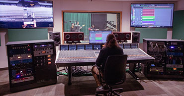 man seated at a audio production set up