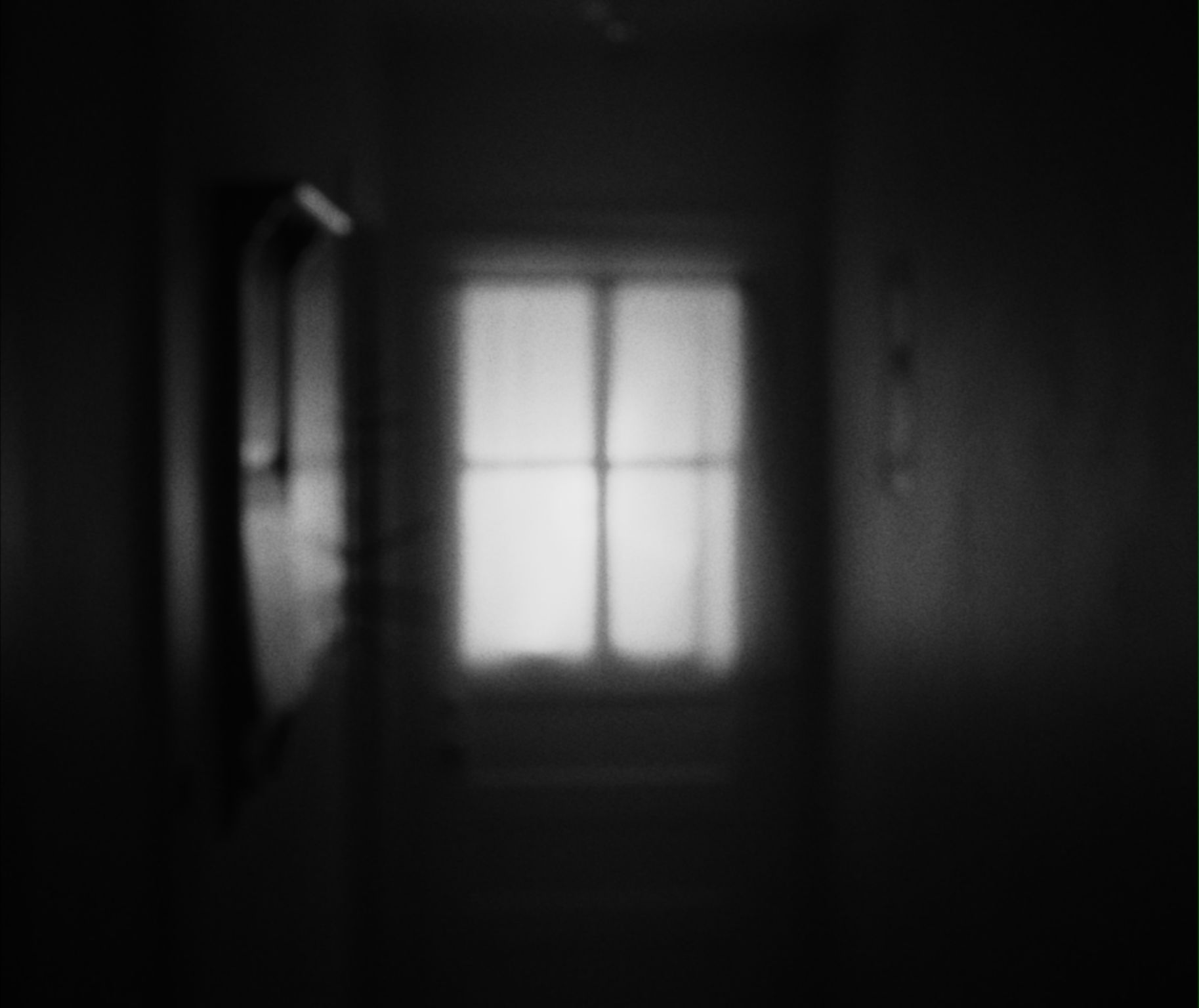 an empty hallways with a window at the end