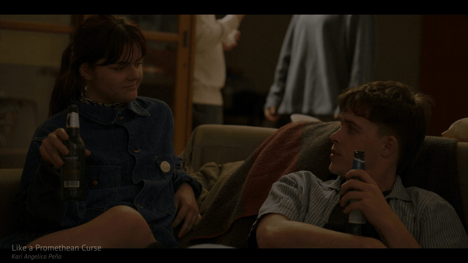 two people talking on a couch holding bottles