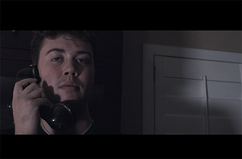 A man on the phone in a dark room