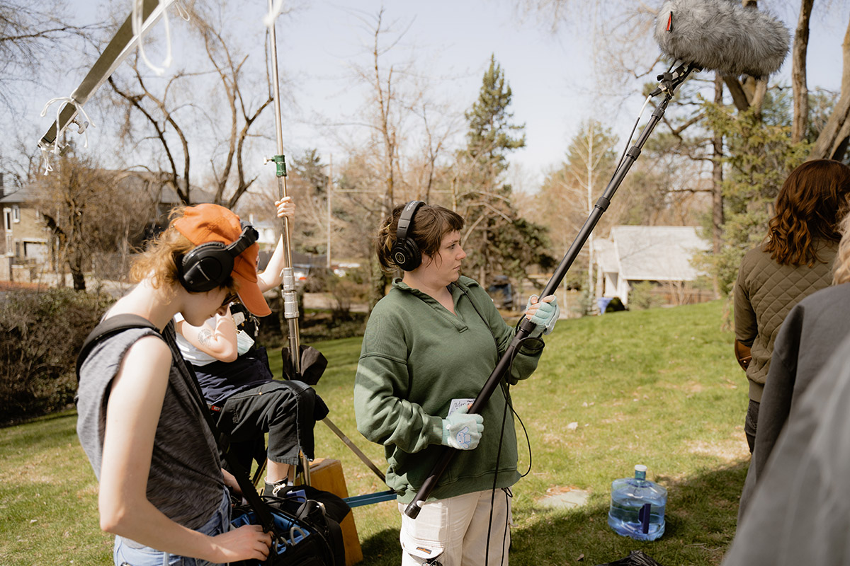 students outside on set holding a microphone