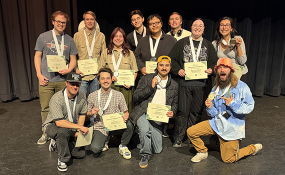 a group of students wearing medals and holding paper certificates