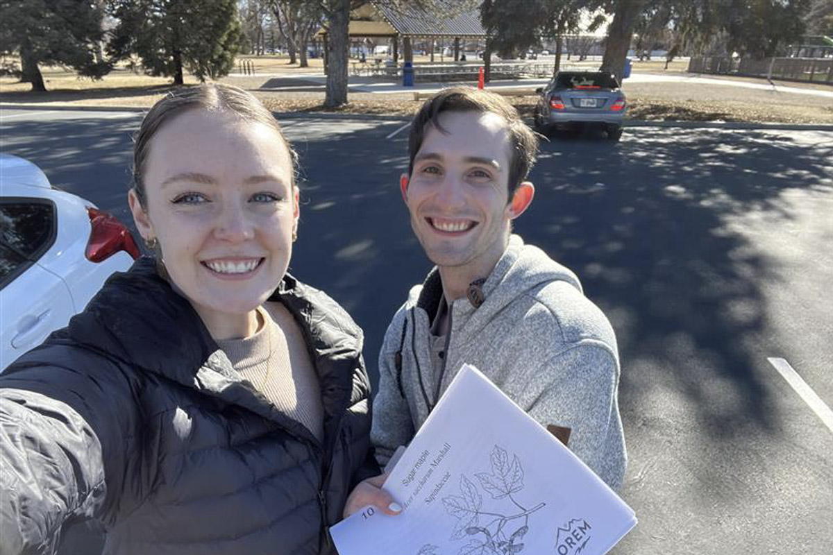 two people outside holding a paper worksheet