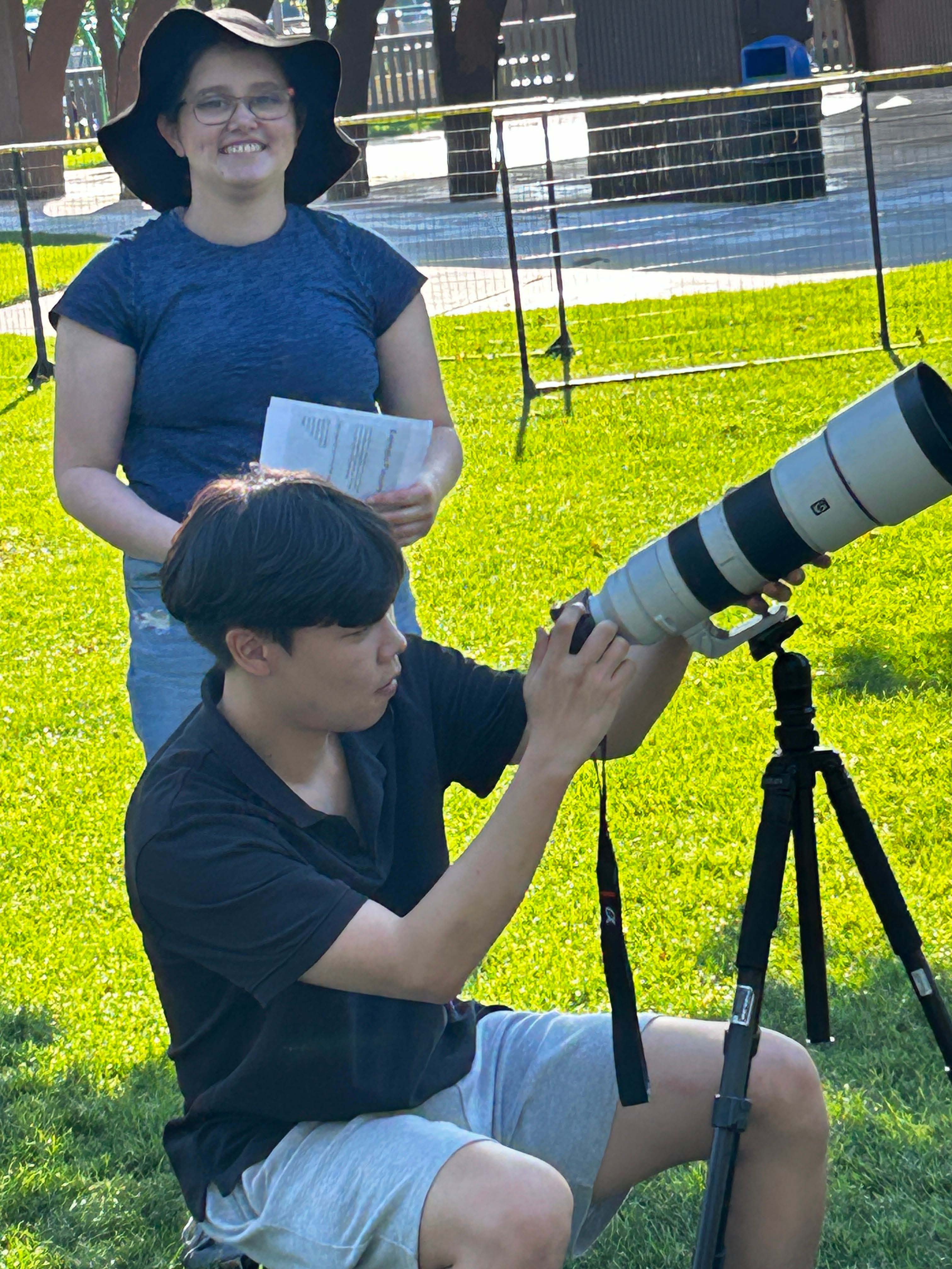 two people using a camera outside