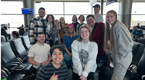 Group of kids posing for a picuture at the airport