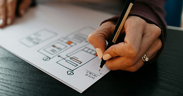 close up of a person sketching a website